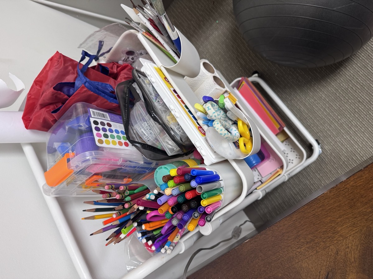 An art cart stocked with pens, markers, and paints